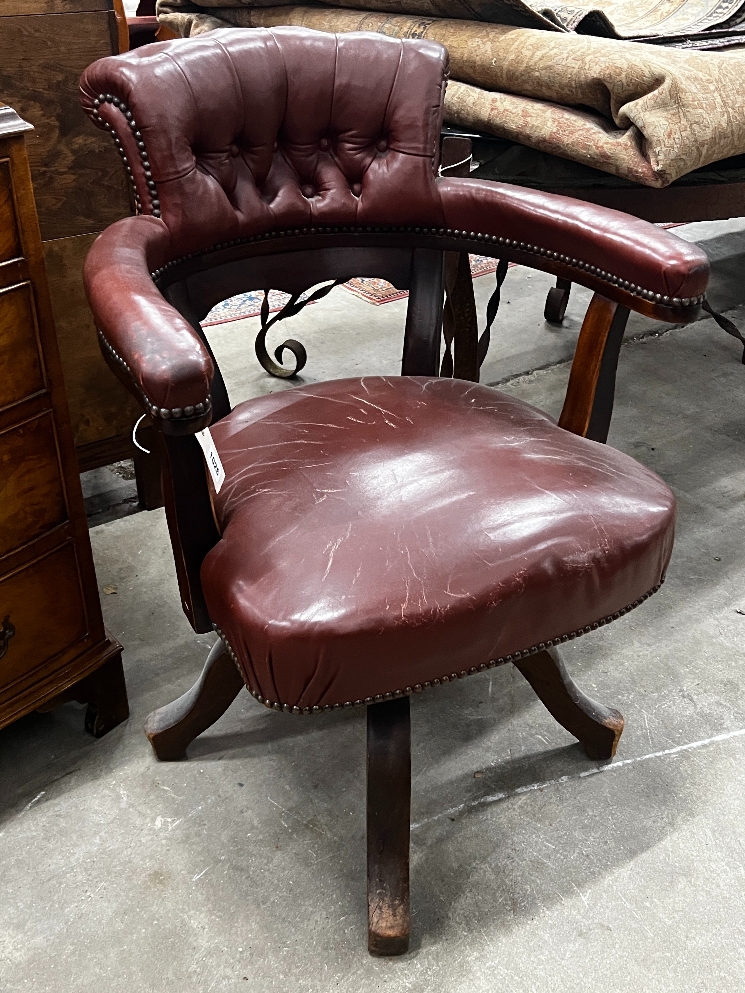 An early 20th century burgundy leather tub framed swivel desk chair, width 61cm, depth 50cm, height 89cm